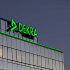 DEKRA-Hauptverwaltung in Stuttgart bei D&auml;mmerung mit leuchtendem DEKRA-Logo