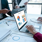 Gesch&auml;ftsleute analysieren Diagramme und Berichte an einem Laptop