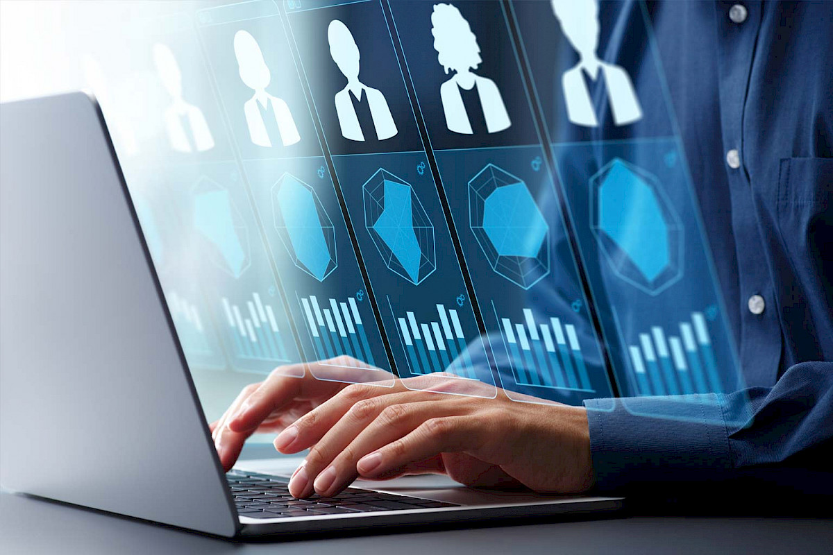 Person am Laptop mit eingeblendeten digitalen Bewerberprofilen und Diagrammen